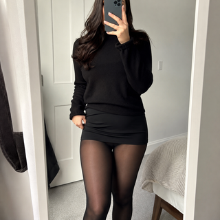 Mirror outfit photo showing MyFleecy tights with a black sweater and mini skirt
